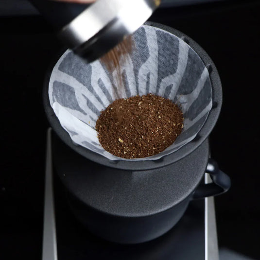 The Hario Alpha coffee dripper in matte black, featuring a minimalist cone-shaped design for manual pour-over brewing.