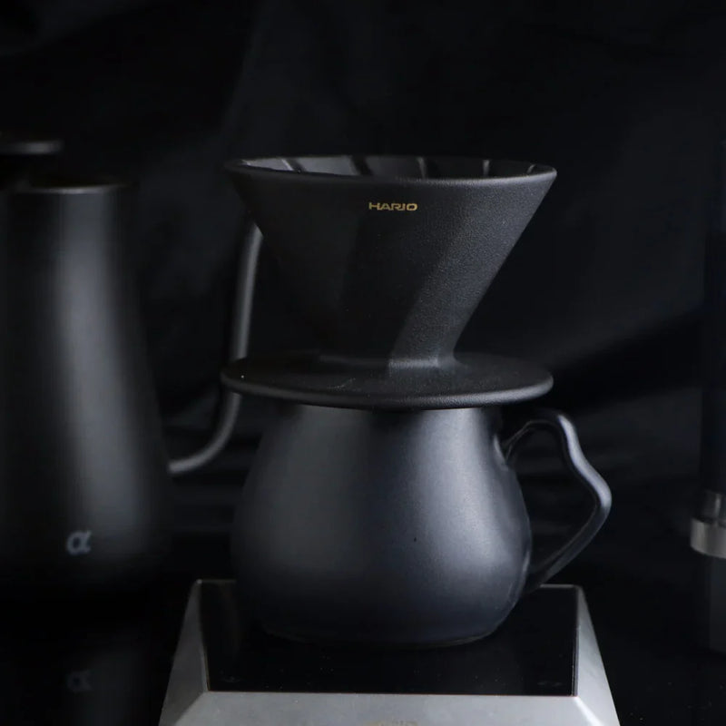 Load image into Gallery viewer, The Hario Alpha coffee dripper in matte black, featuring a minimalist cone-shaped design for manual pour-over brewing.
