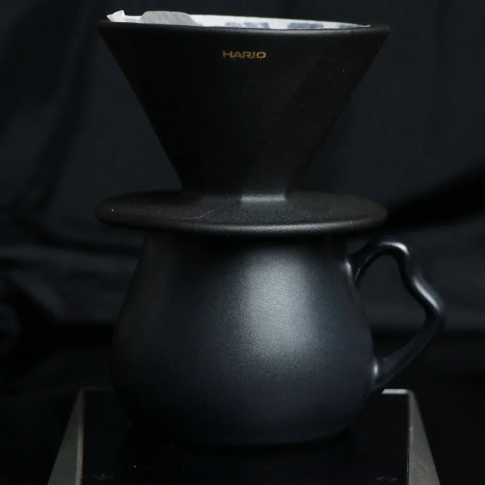 The Hario Alpha coffee dripper in matte black, featuring a minimalist cone-shaped design for manual pour-over brewing.