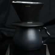 The Hario Alpha coffee dripper in matte black, featuring a minimalist cone-shaped design for manual pour-over brewing.